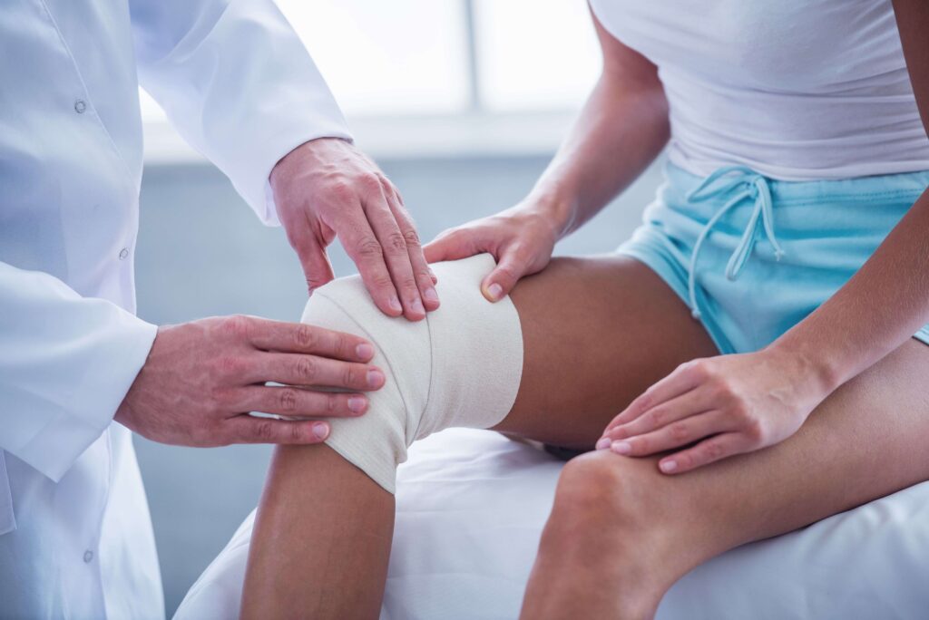 physical therapist checking a patient’s wound dressing